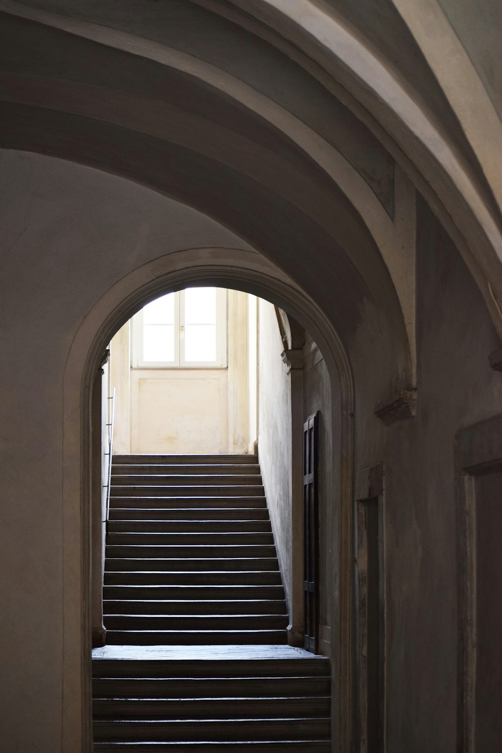 brown wooden staircase in white concrete building