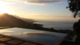 Outdoor infinity pool overlooking a serene sunset landscape.