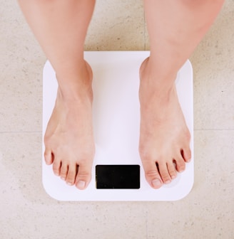 person standing on white digital bathroom scale