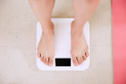 person standing on white digital bathroom scale