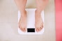 person standing on white digital bathroom scale