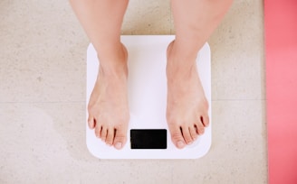 person standing on white digital bathroom scale