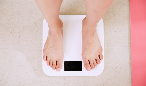 person standing on white digital bathroom scale