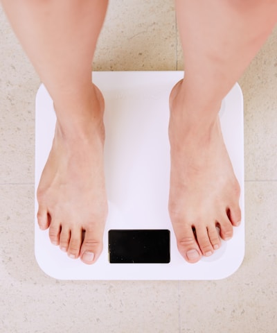 person standing on white digital bathroom scale