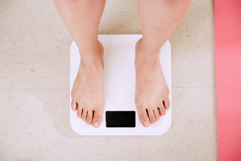 person standing on white digital bathroom scale