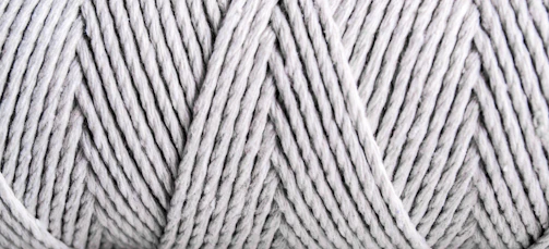 Close-up of soft cotton yarn spools in natural light, highlighting texture and color.