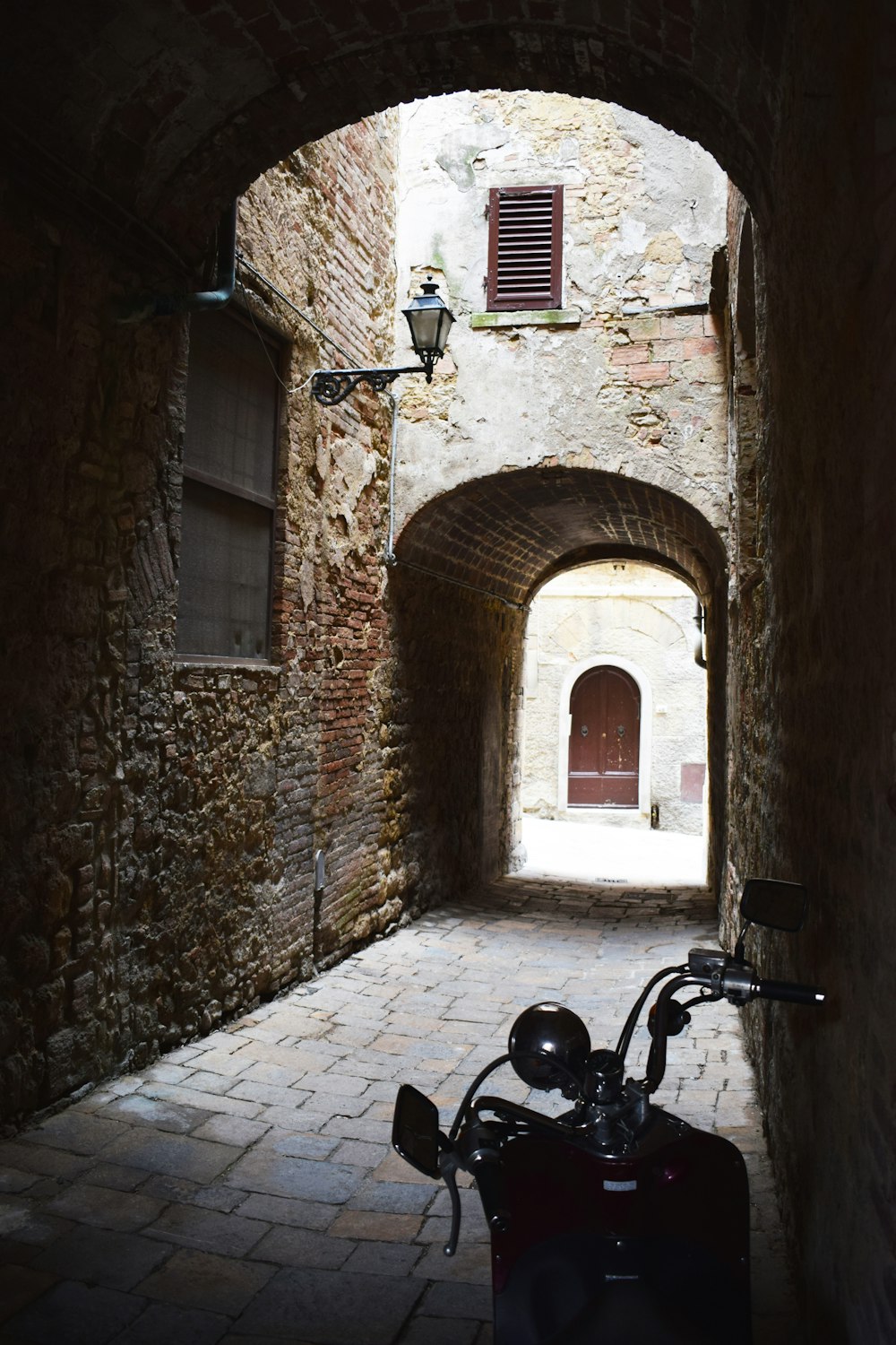 a motorcycle parked in a narrow alley way