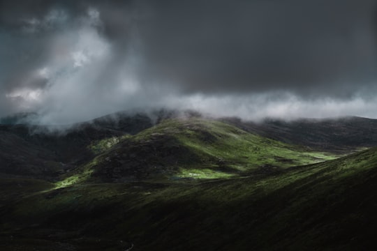 aerial view of green mountain under cloudy sky in Mount Kosciuszko Australia