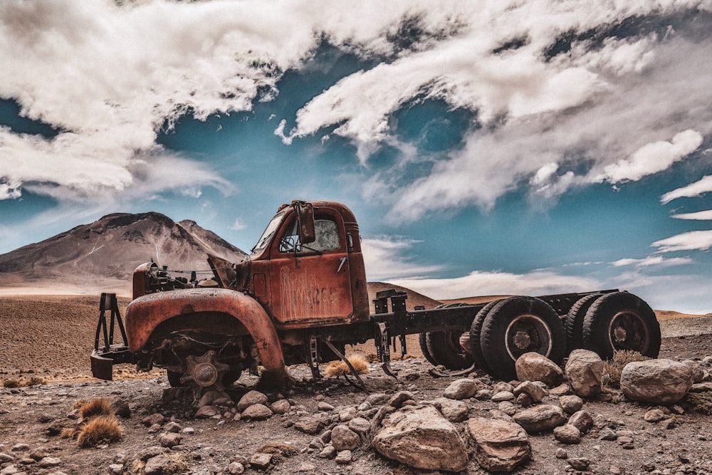 red single cab pickup truck near brown mountain