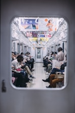 A learner using a smartphone to study language while commuting on a train.