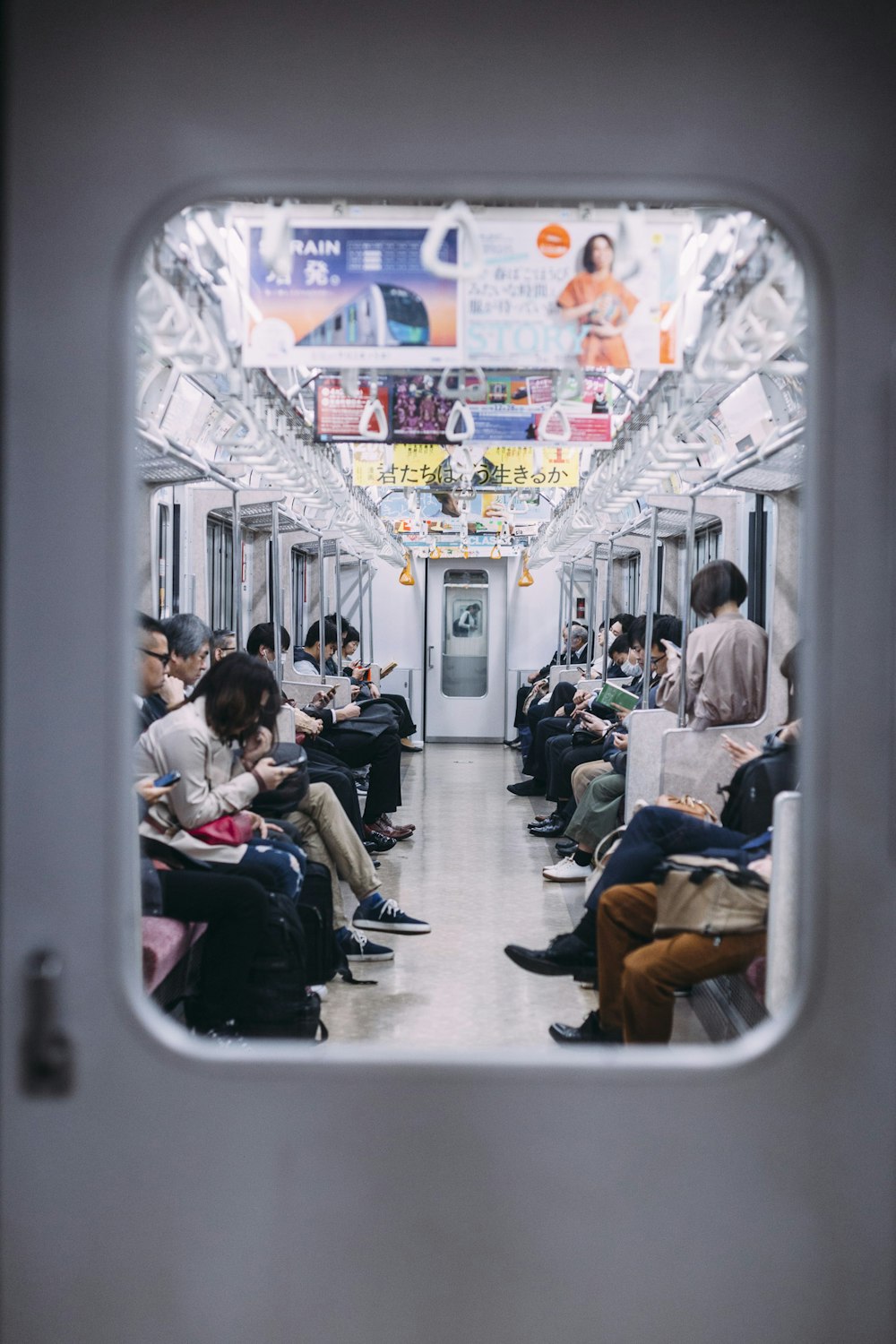 pessoas no trem olhando para seus telefones