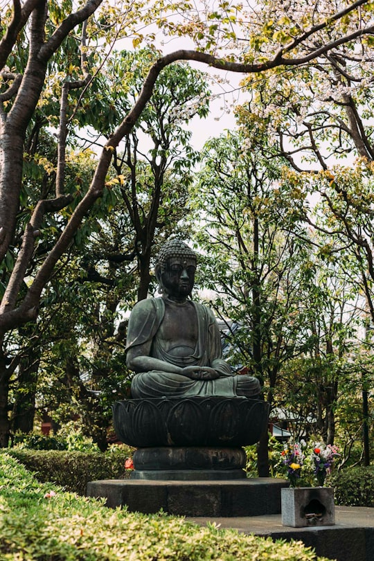 Hotei statue surrounded of t rees in Sensō-ji Japan
