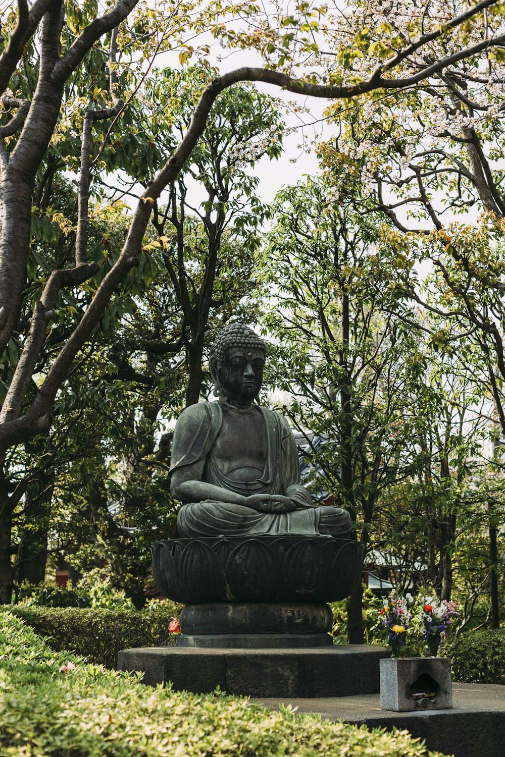 Estatua de Hotei rodeada de trees