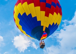 yellow, red, and blue hot air balloon flying during daytime