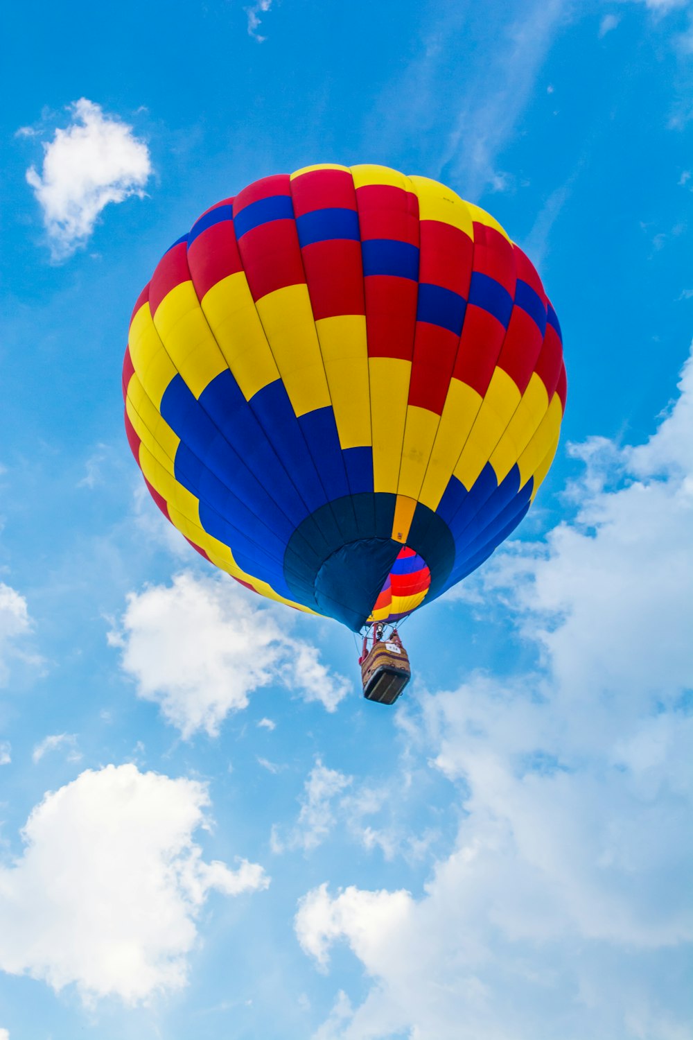 yellow, red, and blue hot air balloon flying during daytime