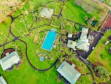 Close-up aerial view of a sleek pool area surrounded by manicured gardens and ambient lighting.