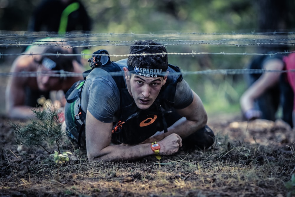 man crawling on barb wire