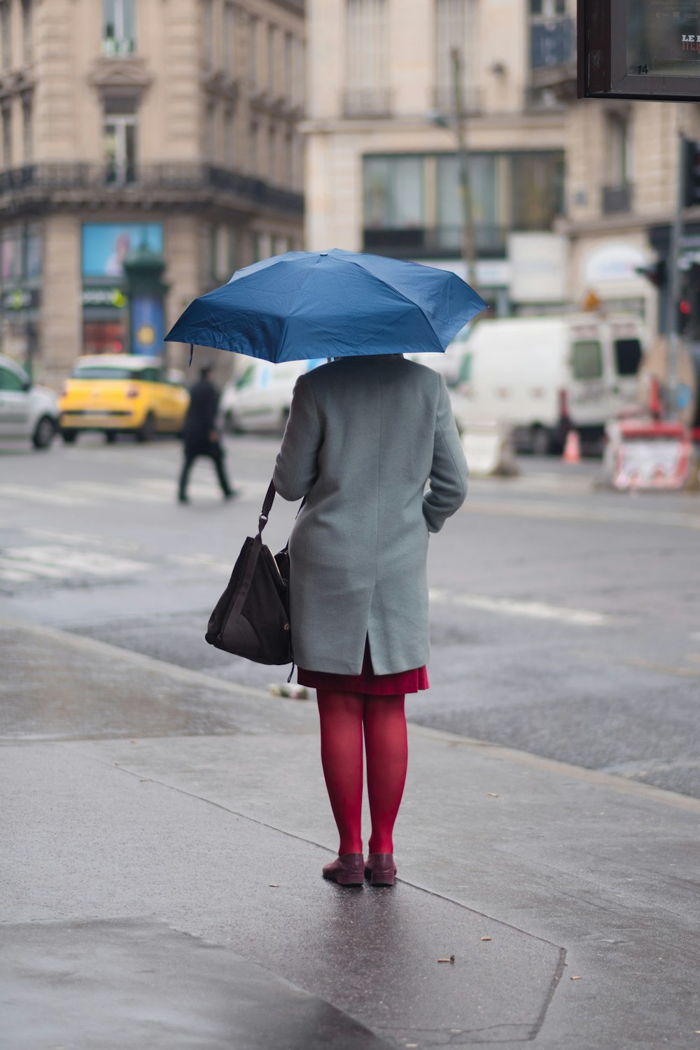 Frau steht und hält Regenschirm