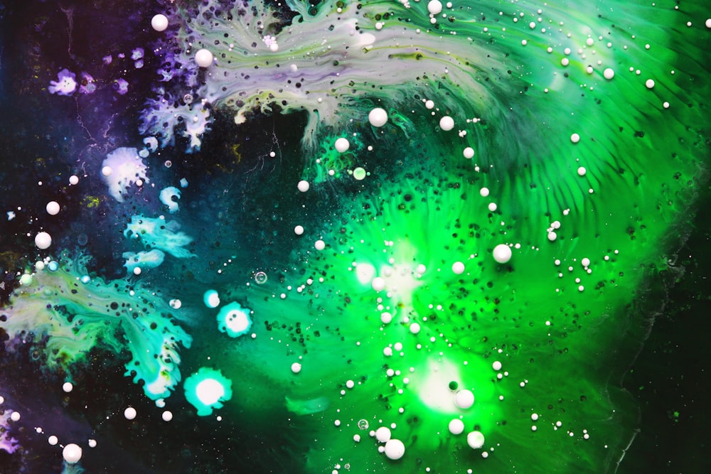 close-up photography of green, white, and purple paint splash