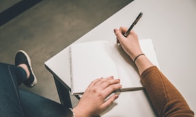 person writing on white paper