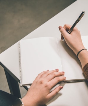 person writing on white paper