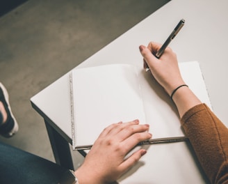 person writing on white paper