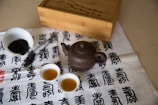 A serene tea setup with traditional Taiwanese teaware and a pot pouring golden tea.