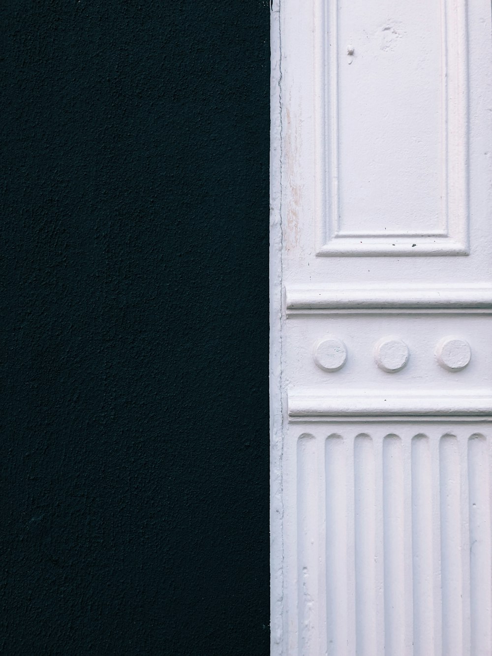 a black and white cat sitting on a white door