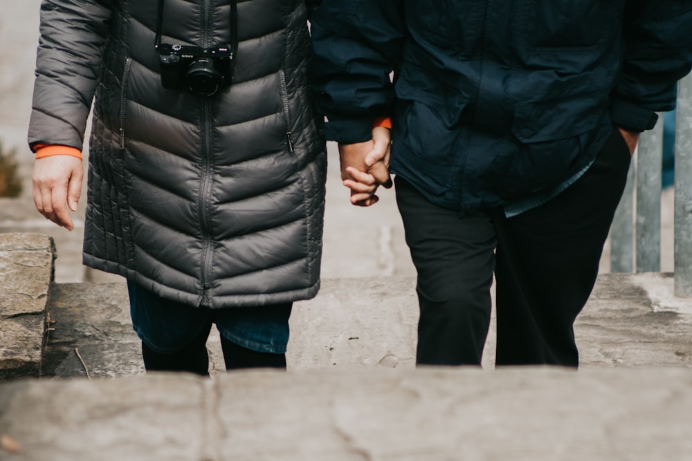 man and woman holding hands walking on stairs