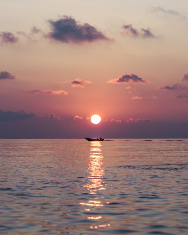 Silhouette of sailing vessel at sunset