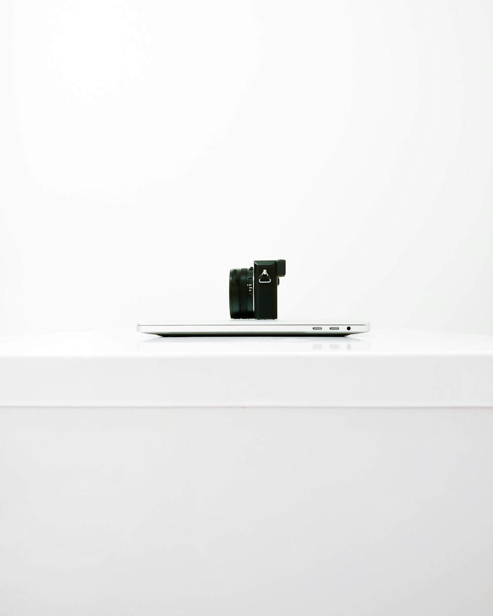 fotocamera mirrorless nera sulla parte superiore del MacBook