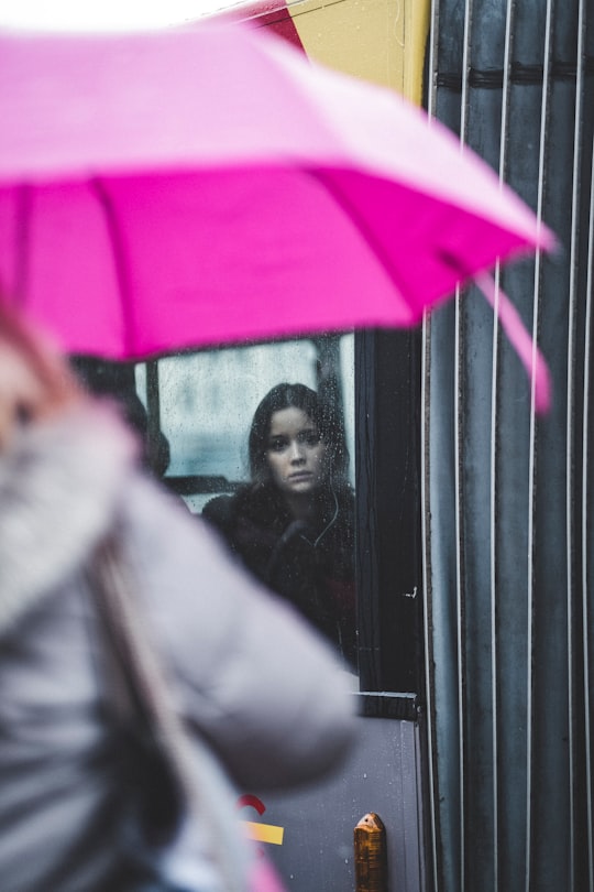 woman standing inside glass window in Liège Belgium