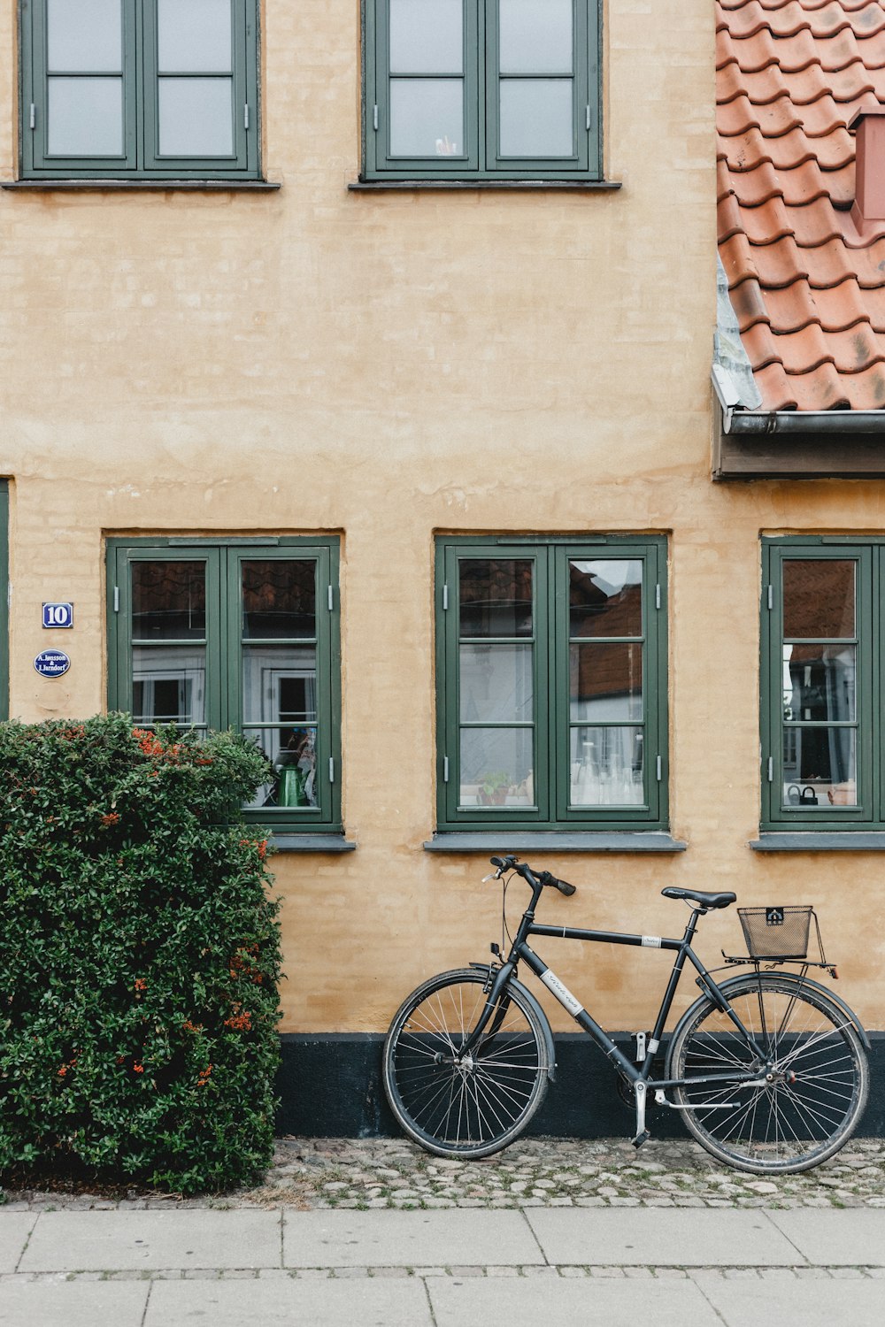 grey bicycle beside concrete building