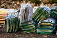 A stack of discount coupons with tropical designs scattered on a sandy surface.