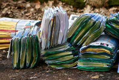 A stack of colorful zines and short books with vintage film grain textures on a concrete ledge.