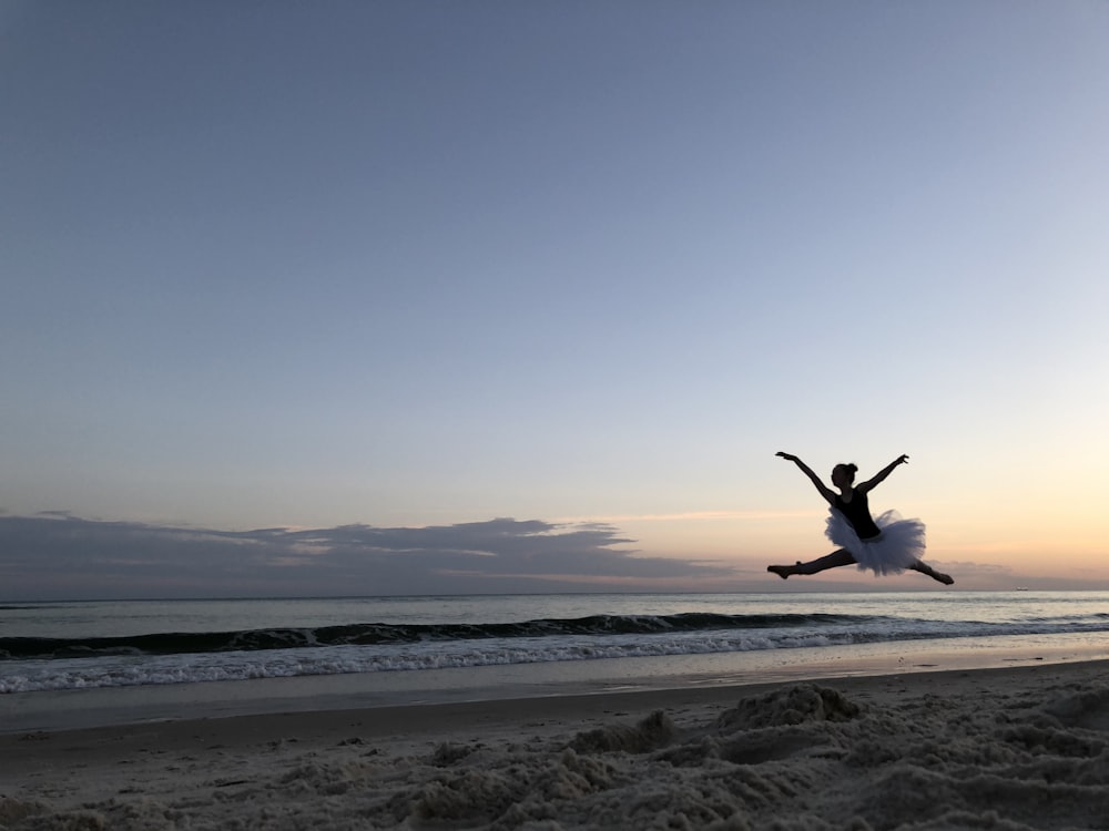 silhouette of ballerina jumping on air