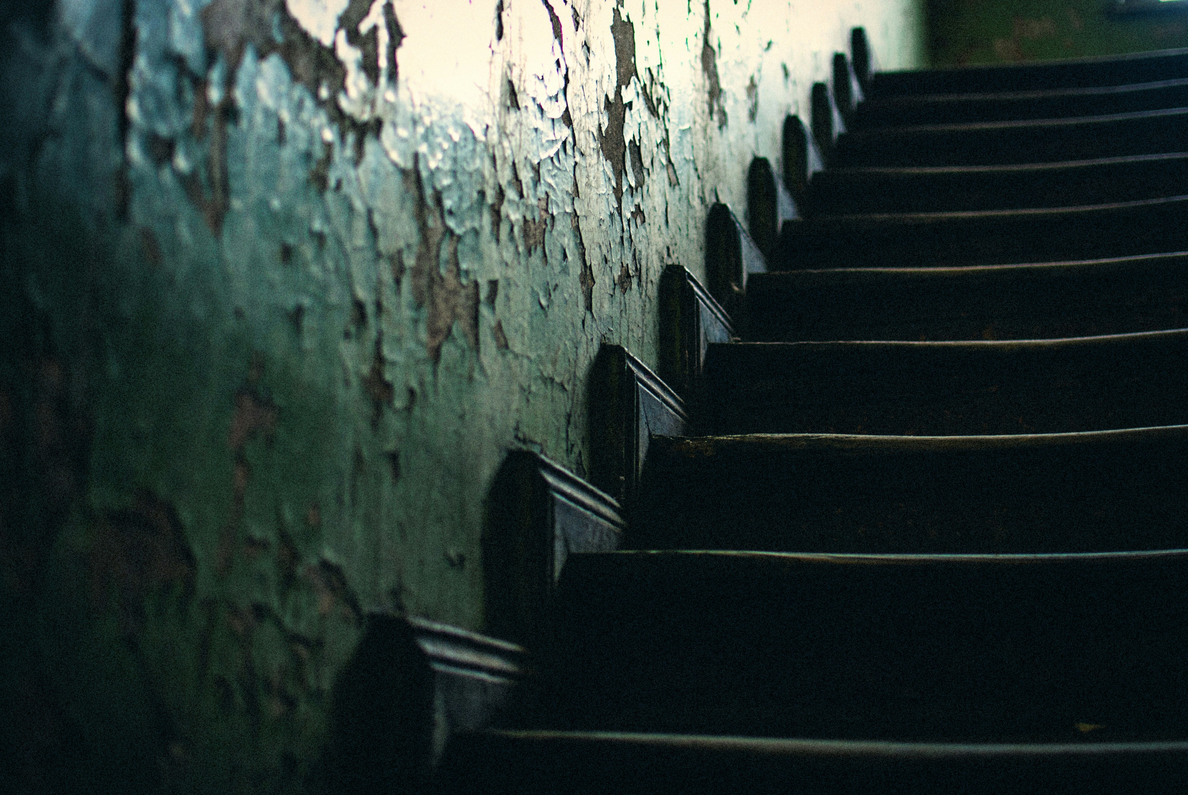 black wooden stairs beside white paint wall