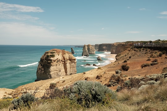 brown rocks in sea shore at daytime in Twelve Apostles Marine National Park Australia