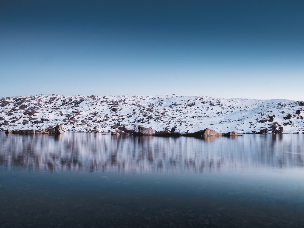 landscape photo of body of washer near mountain