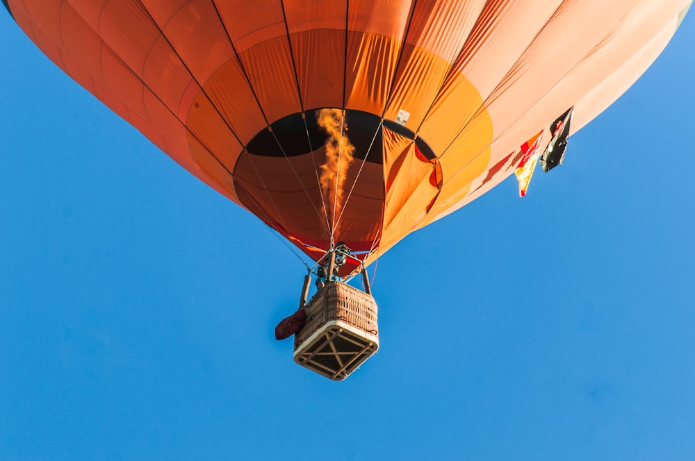 Persona montando un globo aerostático naranja