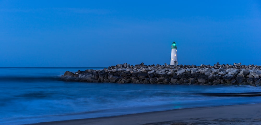 white lighthouse on rock formation