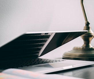 silver laptop computer near brown table lamp