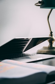 silver laptop computer near brown table lamp