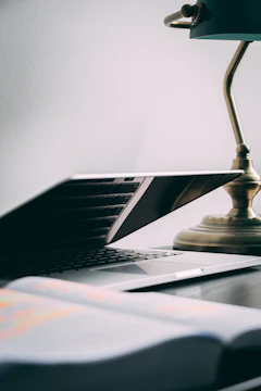 Image of legal books and a laptop on a desk with natural light.