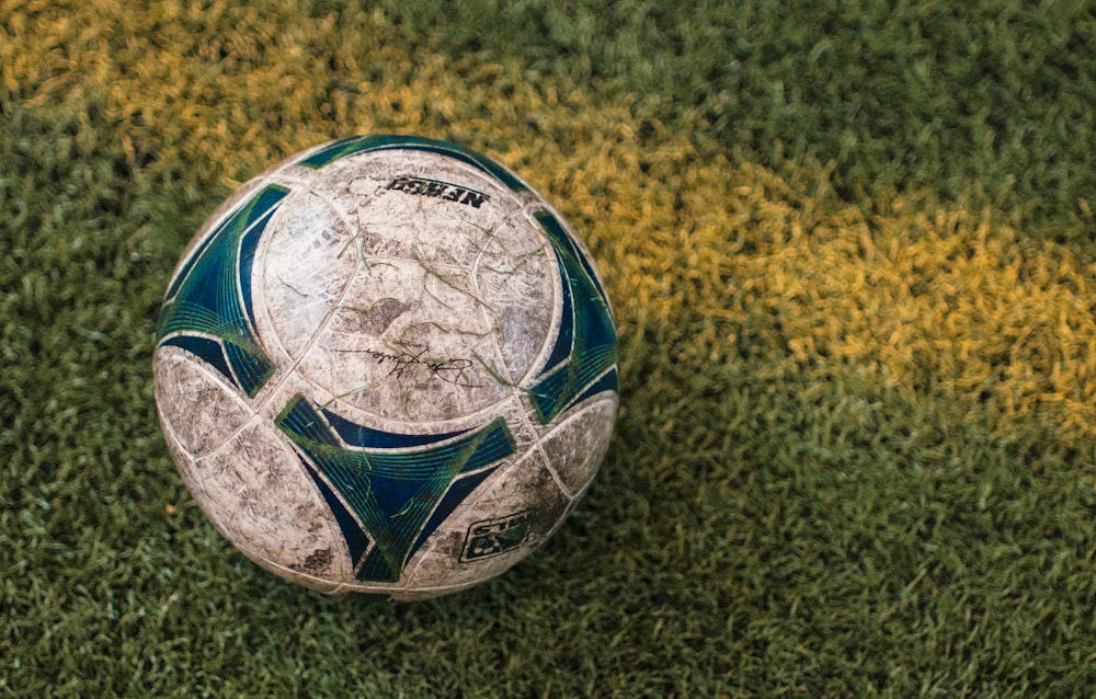 blue and white soccer ball on ground