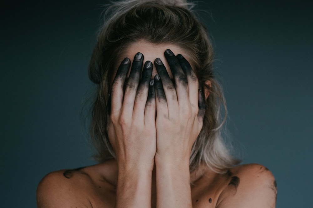 woman covering face with both hands closeup photography