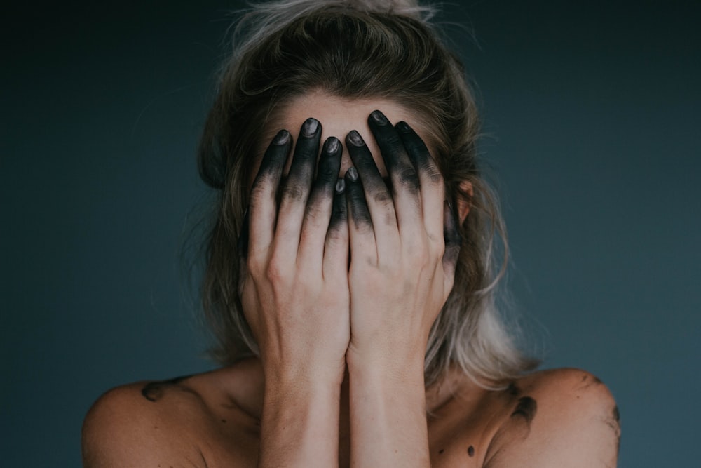 femme couvrant le visage avec les deux mains photographie en gros plan