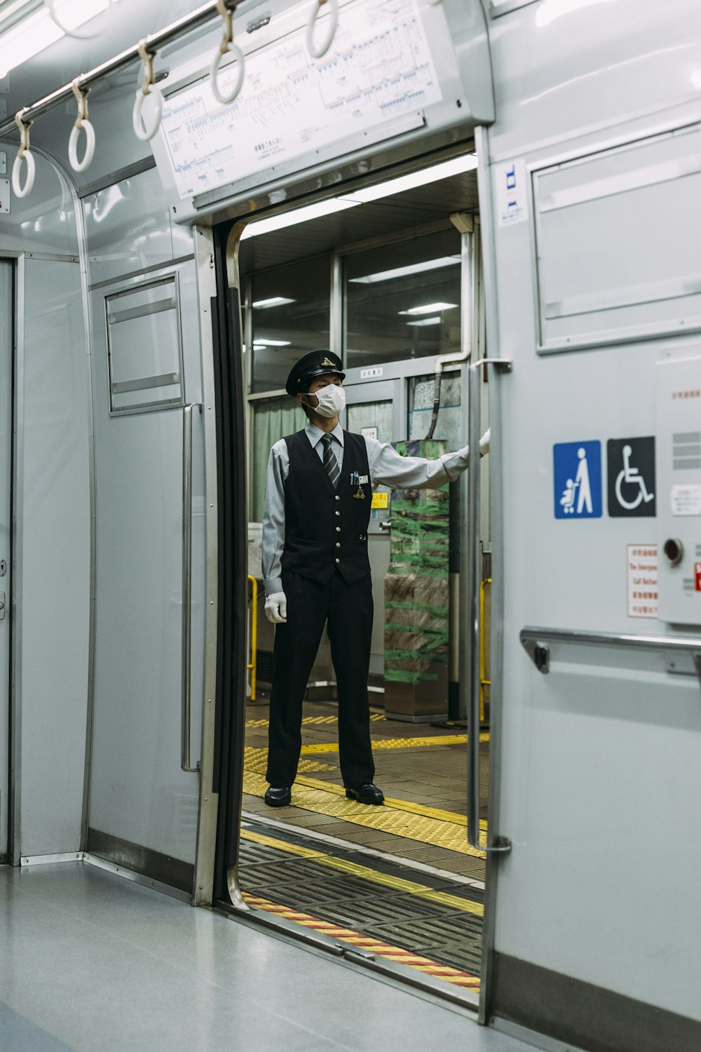 Guarda masculino em vestido preto e branco em pé em frente à estação de trem