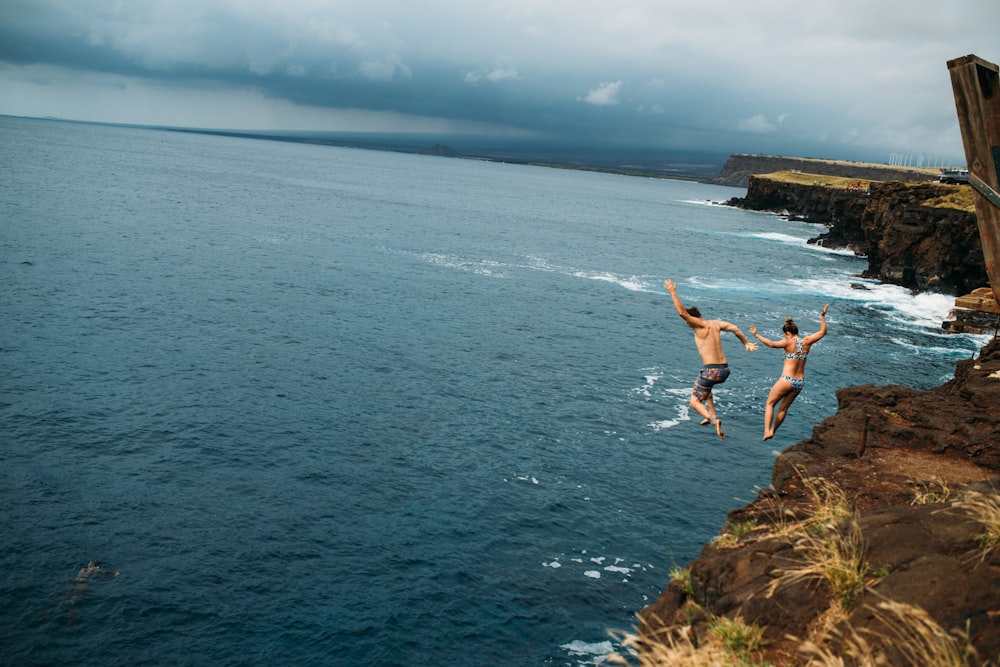 two woman jump into water