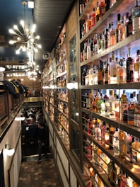 Cozy bar interior with warm lighting and bottles neatly arranged on shelves.